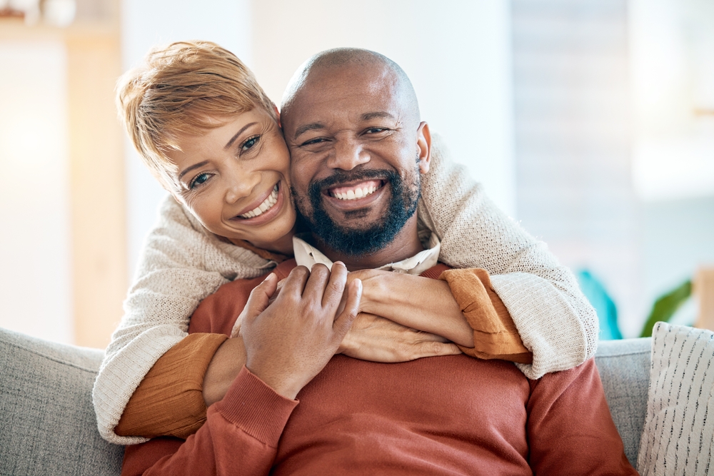 couple sitting on the couch smiling and hugging